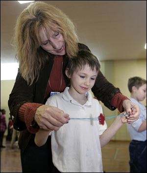 CTY SCIENCE29p    The Blade/Lori King     01/28/2011  Special Ed teacher Cathy Arent helps 3rd grader Jonathan Fox with a project during the Science Festival at Walbridge Elementary in Toledo, Ohio. The fest is put on by Imagination Station.