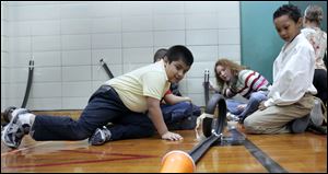 CTY SCIENCE29p    The Blade/Lori King     01/28/2011  3rd graders Jose Delgado, front left, and Jesus Wyatt, front fight, experiment with marbles on a track during the Science Festival at Walbridge Elementary in Toledo, Ohio. The fest is put on by Imagination Station.