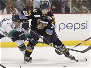 The Walleye's Mike Hedden (28) battles Florida's Bobby Raymond for the puck during the first period at the Huntington Center. 