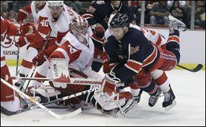 New York Rangers left wing Wojtek Wolski, right, of Poland, reaches for the loose puck in front of Detroit Red Wings goalie Jimmy Howard (35) during the second period.