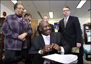 Mayor Mike Bell smiles after signing a memorandum between the city and Chinese investors. From left are Councilmen Wilma Brown and Mike Craig, buyers agent Scott Prephan, and Councilman Rob Ludeman.