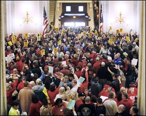 Protesters fill the Statehouse Routunda in Columbus as a Senate panel discusses a proposal to overhaul Ohio's labor laws that were approved in 1983. The proposed measure would outlaw collective bargaining by state employees, including those at public universities. Ohio lawmakers continued to debate into the night.