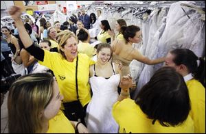 Lauren Grace, center, is hugged by her aunt, Diane Wood, after selecting her wedding gown during the 'Running of the Brides.