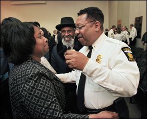 Newly promoted Toledo Police Captain Benjamin Tucker, right, is congratulated by his wife, Patricia Tucker.