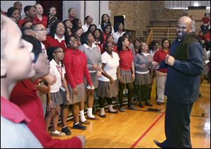 Jason Carter, right, leads the gospel choir at Toledo's Central Catholic High School in a song that he co-wrote.
