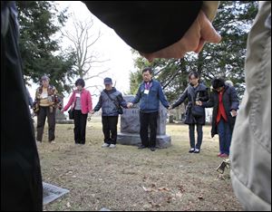 The Rev. Koo Jong Mo, a Seoul pastor, leads prayer at Dr. Horace Newton Allen’s grave in Woodlawn Cemetery.