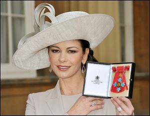 Actress Catherine Zeta Jones displays the insignia after she was made a Commander of the British Empire.