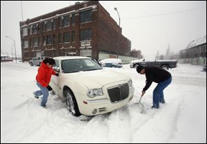 

Bianca Pecina, a Chariott Foods Inc. worker, and her boss, Mike Okdie, shovel out her car on South Superior Street. The storm broke a February record set in 1900.