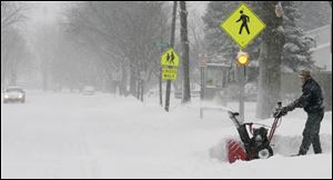 Chuck Tubbs operates a snowblower in his driveway on Dussel Drive in Maumee. Even the snow that he piled up should melt soon. Forecasts call for a high of 50 degrees and rain on Monday. And Sunday's high of 39 degrees should get the melting process under way.