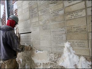 

Darrell Paterson of Spartan Construction replaces the cornerstone of Warren AME Church on Collingwood Boulevard. The time capsule from 1864 was not behind the stone.