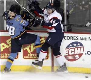Mike Hedden, left, is smashed into the boards while battling for the puck with Kalamazoo's Mitch Versteeg. After the Walleye fell behind 4-1, they eventually tied it when Hedden scored in the second.