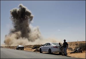 Smoke raises following an air strike by Libyan warplanes near a checkpoint near to the anti-Libyan Leader Moammar Kaddafi rebels checkpoint in the oil town of Ras Lanouf, eastern Libya. 