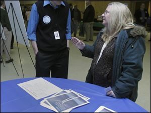 Mark Deveraux, a representative of Consumers Energy, talks with Brenda Reyome of Palmyra, Mich., during the Blissfield Wind Energy open house. A meeting of Ogden Township trustees will be held at 7 tonight in the Ogden Township Hall in Blissfield to discuss the potential impact of wind energy. 