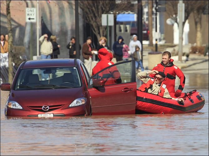 Findlay firefighters pull an unidentified man from his car in Findlay.