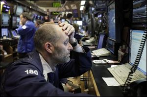 Trader Jason Weisberg works in his booth on the floor of the New York Stock Exchange Thursday.