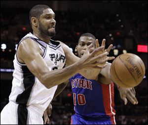 San Antonio Spurs' Tim Duncan, left, and  Detroit Pistons' Greg Monroe, right, scramble for a rebound during the third quarter.