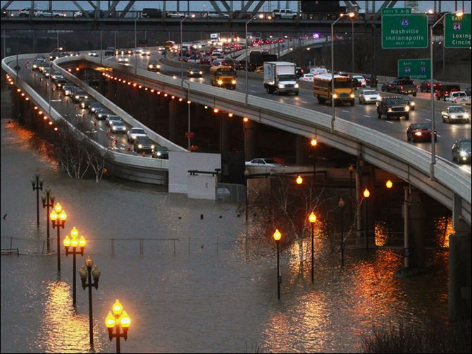 The Ohio River floods under the Third Street exit ramp from I-64 in downtown Louisville, Ky., during rush hour Thursday.