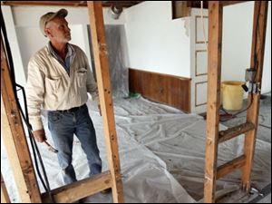 Contractor David Rumpf works on a house on Christie Boulevard in Toledo's Westgate area that was foreclosed on two years ago.