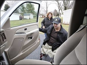 Shane Parsons prepares to get into the family vehicle in Fostoria with his mother, Cindy Parsons. She says that if she were not able to care for her son, the federal government would incur greater expenses.