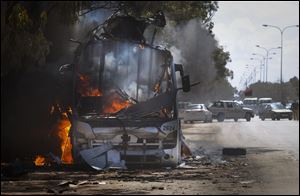 A bus burns on a road leading to the outskirts of Benghazi, eastern Libya, though it's not clear how or who destroyed it.