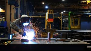 A welder at a Mettler Toledo factory in Columbus assembles components for a truck scale that will be able to weigh 18-wheelers 