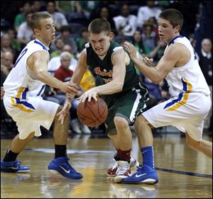 Toledo Central Catholic High School player Drew Lehman, 20, dribbles between Findlay High School players Kyle Boyd, 10, and Grant Birchmeier, 4, during the fourth quarter at Savage Arena at the University of Toledo Thursday.