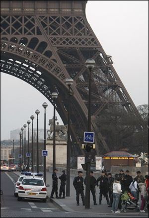 Police officers block the access to the Eiffel Tower following a bomb threat in Paris, Wednesday. A suspicious package and phoned-in bomb threat prompted the Eiffel Tower to evacuate nearly 4,000 tourists from the Paris landmark, tower officials and police said.