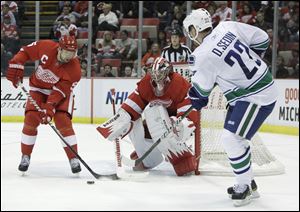 Vancouver's Daniel Sedin, right, who had two goals, shoots at Detroit goalie Jimmy Howard as Nicklas Lidstrom comes to help.