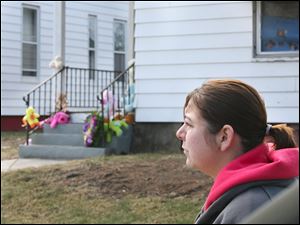 Aubrey Ibarra stops at the memorial set up on the steps of 1319 Hamilton St., where four bodies were found together in the living room. The house had no central heat, and the family was using a gas-powered generator.