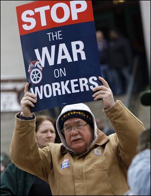 Larry Cerne of Cleveland, one of the protesters out side the Statehouse during the House committee vote, shows his opinion about the bill.
