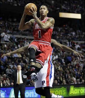 Chicago's Derrick Rose (1) goes to the basket past Detroit's Rodney Stuckey.