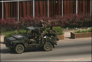 Soldiers loyal to Laurent Gbagbo patrol a street in the central Plateau neighborhood of Abidjan, Ivory Coast, Saturday.