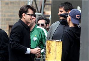 Charlie Sheen, the former ‘Two and a Half Men’ television star, greets fans after stepping
off his tour bus in Detroit, the start of his 20-city ‘Torpedo of Truth’ tour. The 5,100- seat Fox Theatre was packed, but the unhappy crowd started leaving before he ended.