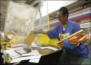 Terry Robinson sorts mail United States Postal Service sorting facility in Toledo.