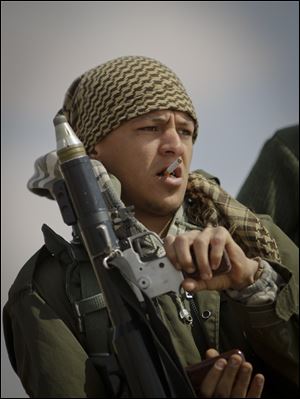 An anti-government Libyan rebel holds a rocket propelled grenade launcher near Brega, Libya, where the battle lines changed only slightly on Sunday.