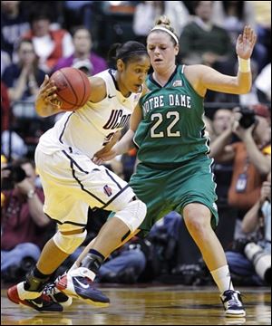 Connecticut's Maya Moore, left, drives on Notre Dame's Brittany Mallory (22).