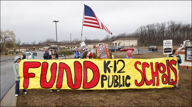 Members of the Bedford Education Association conduct an informational picket outside Monroe Road Elementary School in Lambertville, Mich.
