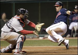 Cleveland Indians' Asdrubal Cabrera scores as Boston Red Sox catcher Jarrod Saltalamacchia waits for the ball in the fifth inning.