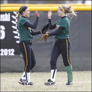 Clay High School players Danielle Holmes (2) left, and Kim Crawford (7) right, high five during warmups before the Eagles play Perrysburg.
