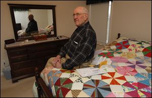 Erie Township resident Joe Bodi, 78, sits on the bed where he was sleeping when four masked gunmen woke him up, forced him out of bed, and held a gun to his head while they searched for valuables.