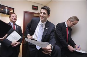 House Budget Committee Chairman Paul Ryan (R., Wis.) center, flanked by committee members, Rep. Todd Akin (R., Mo.), right, and Rep. Bill Flores, (R., Texas), works on Capitol Hill in Washington earlier last week.