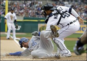 Kansas City runner Billy Butler (16) safely slides under the tag of Detroit catcher Victor Martinez (41) during the second inning.