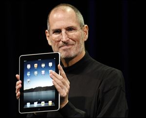 Apple CEO Steve Jobs shows off the iPad during an event in San Francisco.