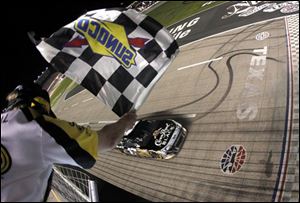 Sprint Cup Series driver Matt Kenseth (17) takes the checkered flag for the victory in the NASCAR Samsung Mobile 500 auto race at Texas Motor Speedway.