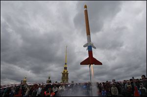 People watch a model rocket blasting off during celebrations of the 50th anniversary of the Yuri Gagarin's first manned flight into space in St.Petersburg, Russia.