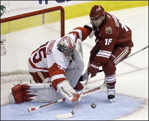 Detroit Red Wings goalie Jimmy Howard, left, makes a save on a shot from Phoenix Coyotes center Matthew Lombardi, right, in the third period of an NHL first-round playoff hockey series in 2010 in Glendale, Ariz. Howard faced 31 shots as the Red Wings won Game 5 by a score of 4-1.