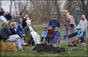 Dressed in French-Canadian pioneer attire, Gene 'Winter Elk' Picor entertains young and old alike as he tells a story at the Fur Trade Day at the Monroe County Historical Museum's Navarre-Anderson Trading Post.