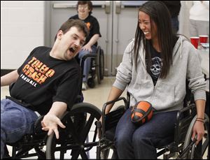 Chris Clarke, left, a member of the Toledo Crash wheelchair football team from Toledo, tries to 'tackle' Chelsea Lasater, of Toledo, during a scrimmage with the UT Rec Therapy Club.