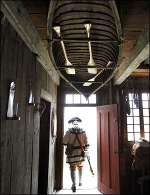 A canoe hangs from the ceiling of the Navarre-Anderson Trading Post as Jim Watko, dressed as a French militianman, heads outside.