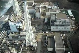 An aerial view shows the damaged reactor building of Unit 4, left, of the tsunami-crippled Fukushima Dai-ichi nuclear power plant in Okuma town, Fukushima Prefecture, northeastern Japan, in this image taken Sunday by T-Hawk drone aircraft and released by Tokyo Electric Power Co. 